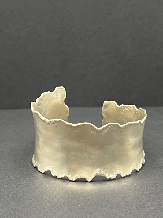 Asymmetrical torn edge cuff