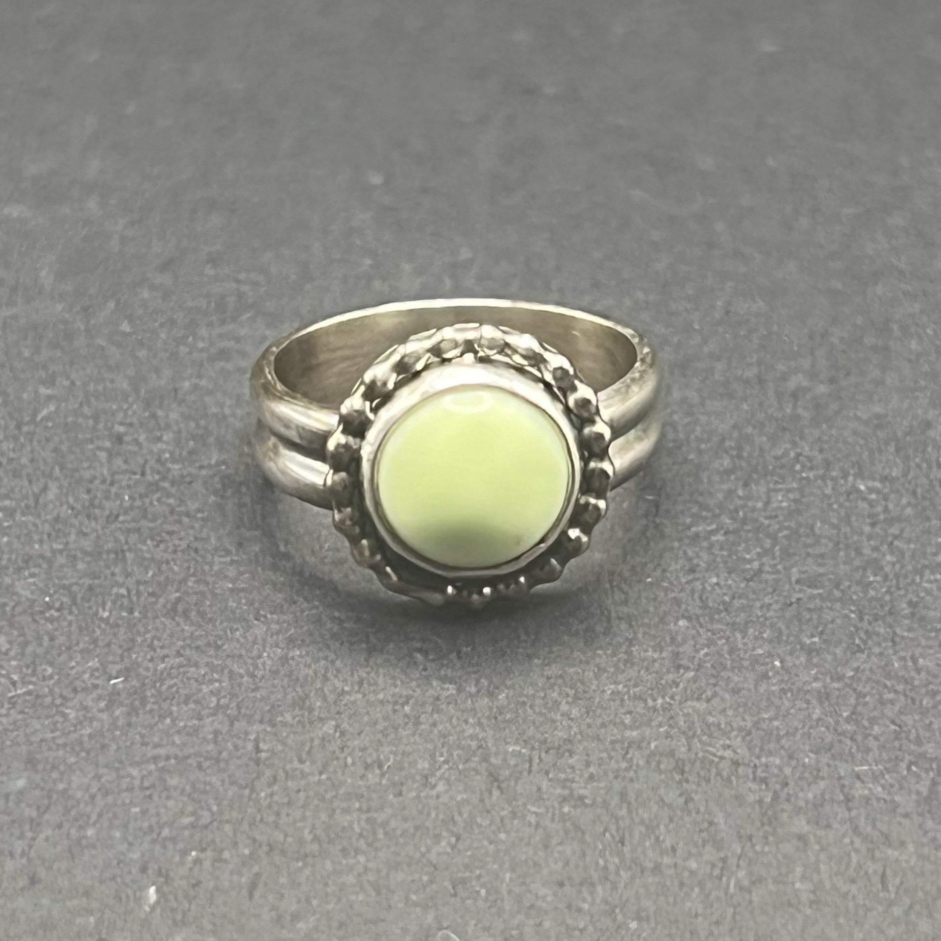 Image shows front side of Lemon Chrysoprase Feature Ring.  Stone is 10mm round, matte, sunny pale yellow color.