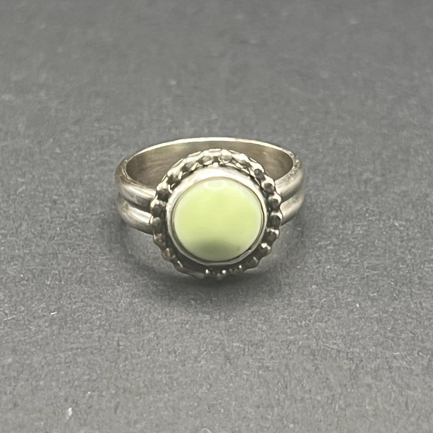 Image shows front side of Lemon Chrysoprase Feature Ring.  Stone is 10mm round, matte, sunny pale yellow color.  
