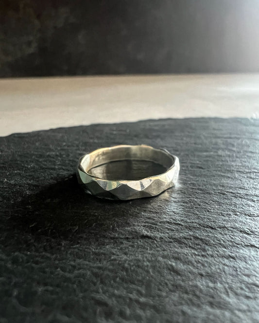 Faceted wide band ring